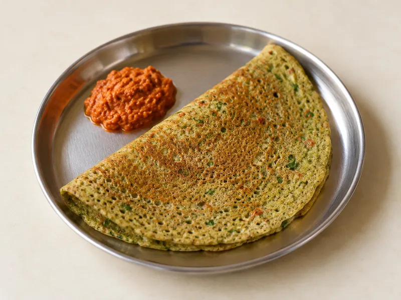 Illustration of Pesarattu served on a steel plate